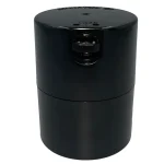En sort, cylindrisk beholder med en glat overflade og en skinnende finish. Låget er fladt og har en let skridsikker struktur. Beholderen har en kapacitet på 290 ml og prydes af et minimalistisk design uden synlige knapper eller symboler. Den er fremstillet af plastmateriale, der giver en robust og holdbar fornemmelse.