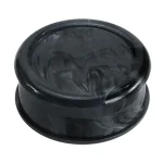 En sort grinder med en glat, mat overflade pryder midten af fokus. Den har en cirkulær form og en tydelig skillelinje, der adskiller det øverste og nederste kammer. På toppen er der et indgraveret logo, der tilføjer et subtilt designelement. Interiøret viser skarpe tænder, der er strategisk placeret til at male indholdet effektivt.