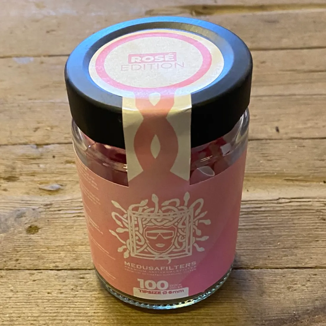 Medusa Filters Rosé Edition 100 stk Ø6 med lyserødt mærkat på det sorte låg og en strimmel ned over glasset.