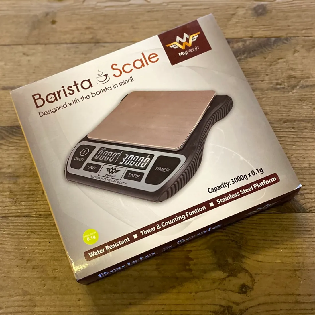 MyWeigh Barista Vægt 0,1-3000g i hvid æske med brunt "Barista Scale"-tryk og digitalt display vist på forsiden.