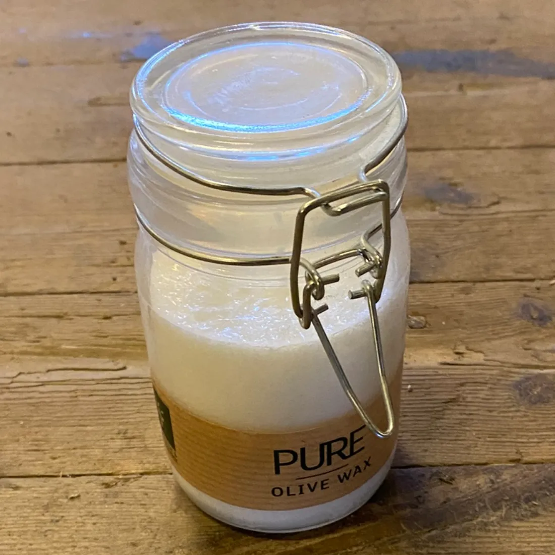Pure Olive Wax Jar Candle White 120×70 cm med lang metallås ned over den brune etiket med "PURE" trykt i sort.