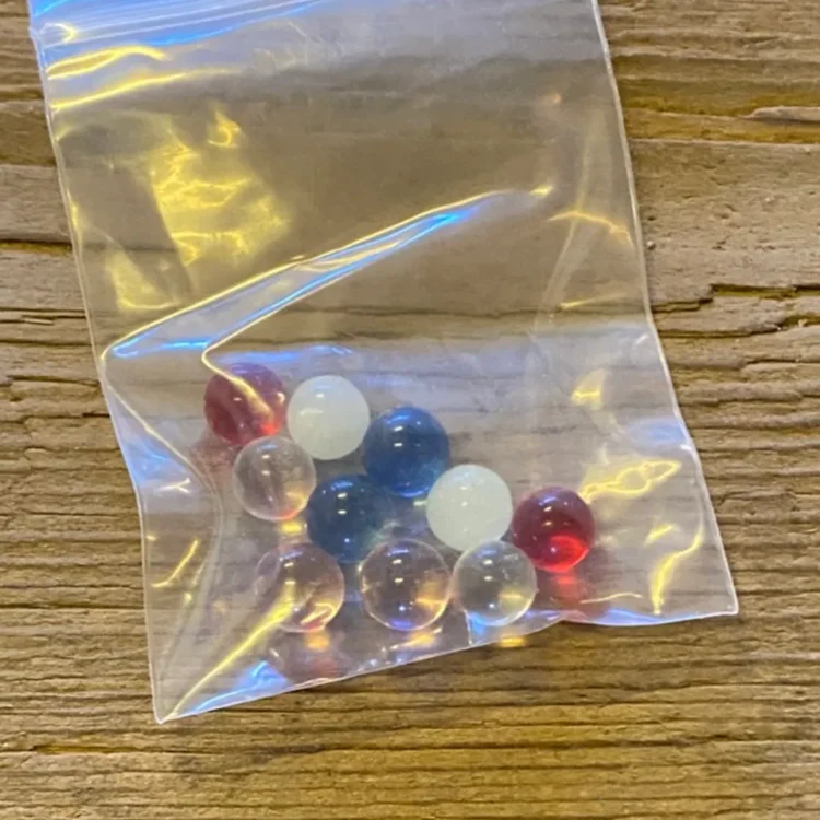 Quartz Glas Terp Kugler (Tilfældig Farve) med blank overflade i klar, hvid, blå og rød, samlet i en klar pose.