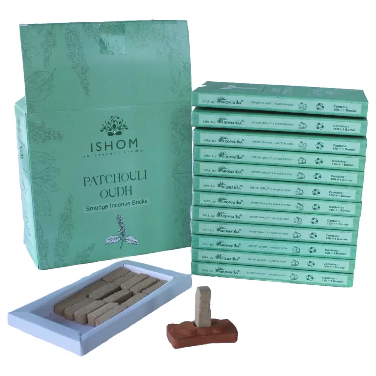 ISHOM Patchouli Wood Smudge Bricks 15 stk i mintgrøn æske med "ISHOM" på fronten. Brune røgelsesstykker i åben bakke.